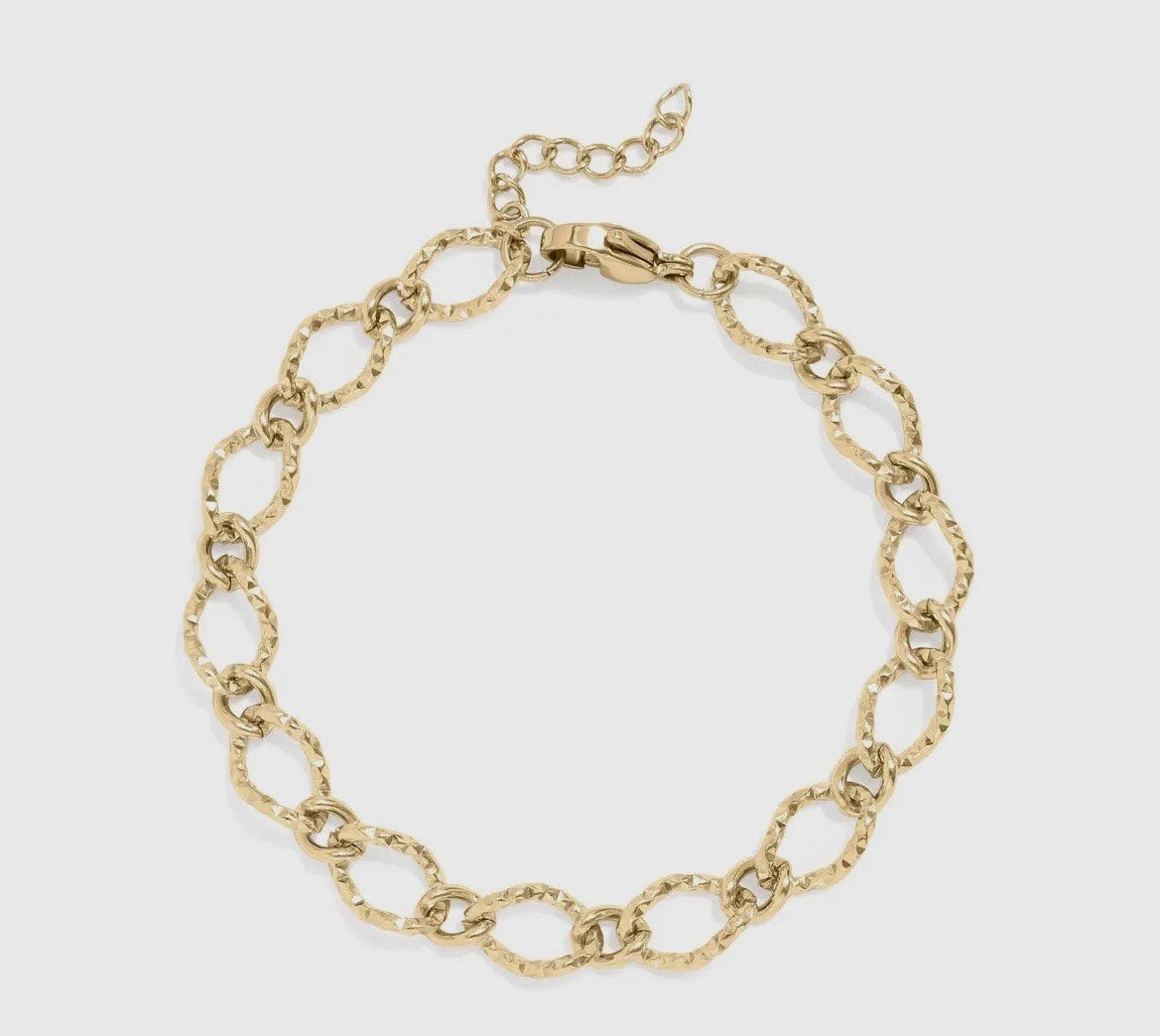 Gold chain bracelet on a light gray background