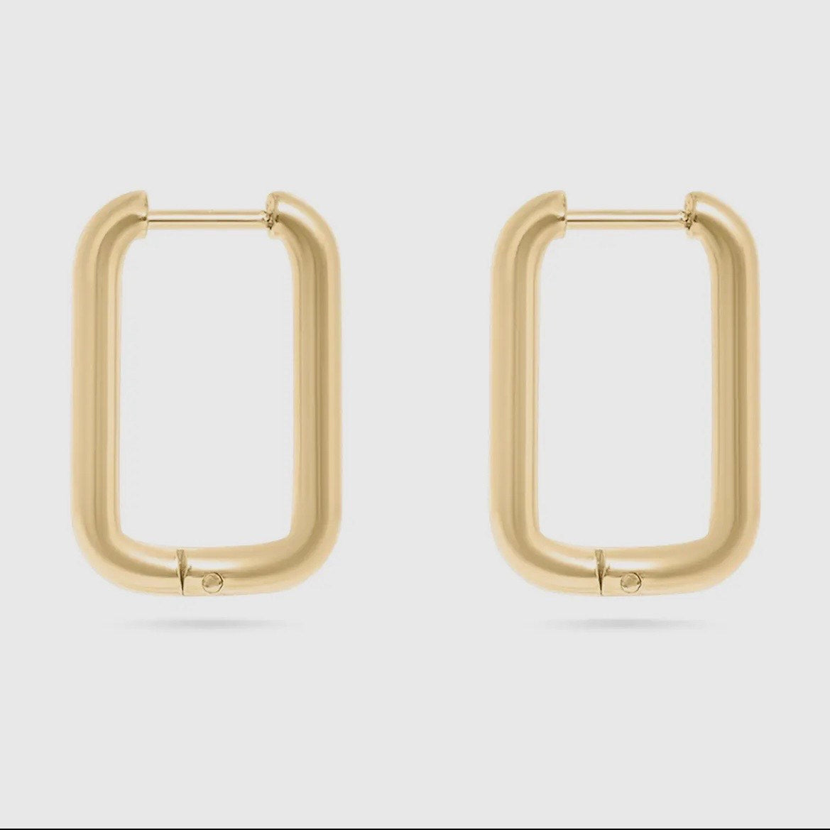 Gold hoop earrings on a light gray background